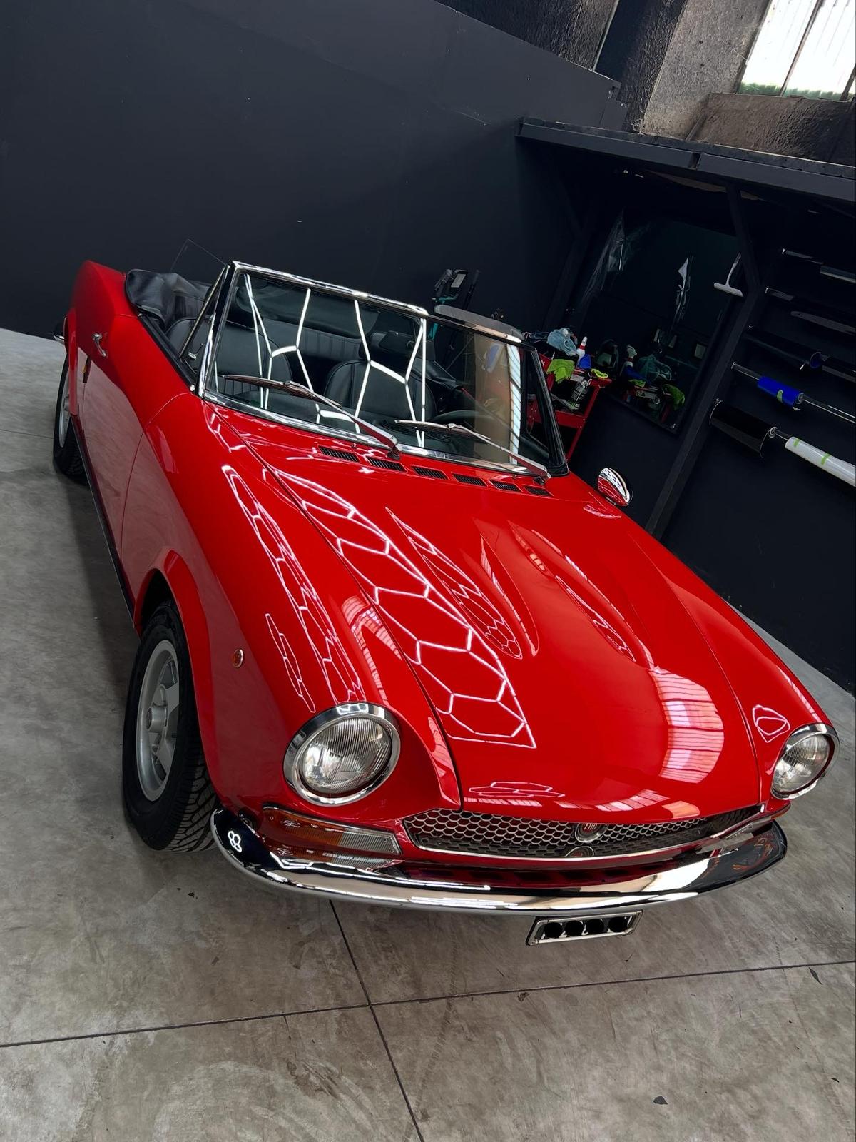 Fiat 124 Sport Spider rossa, curata in atelier e con targa oscurata