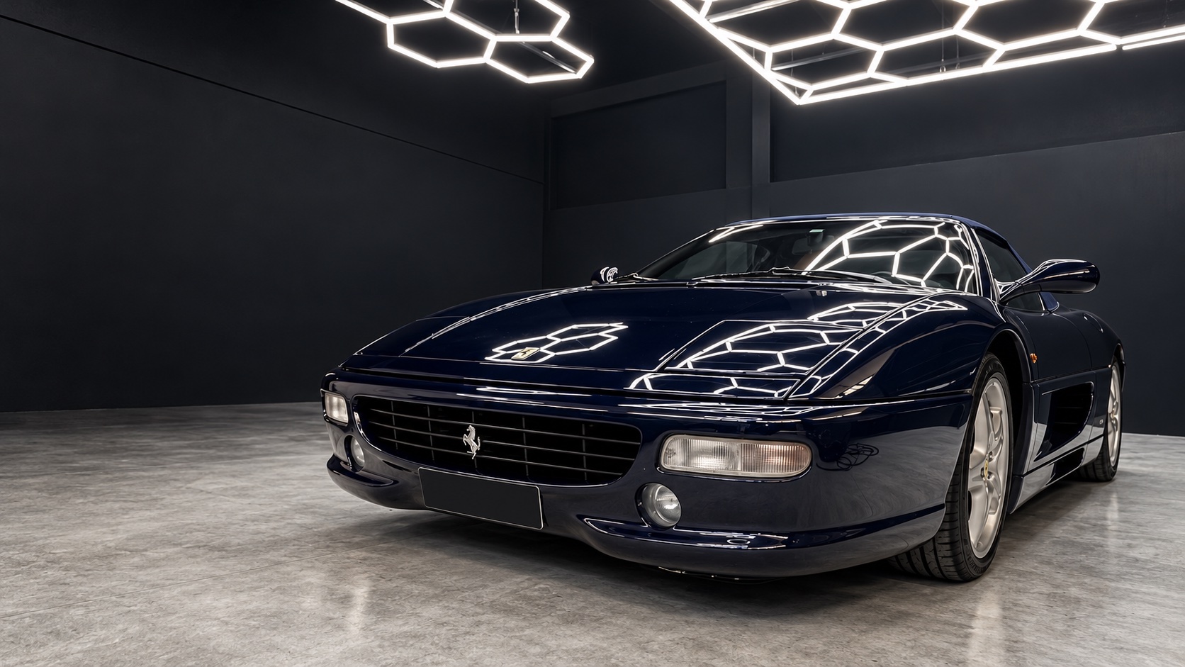 Ferrari F355 Spider blu, con i riflessi delle luci sulla carrozzeria